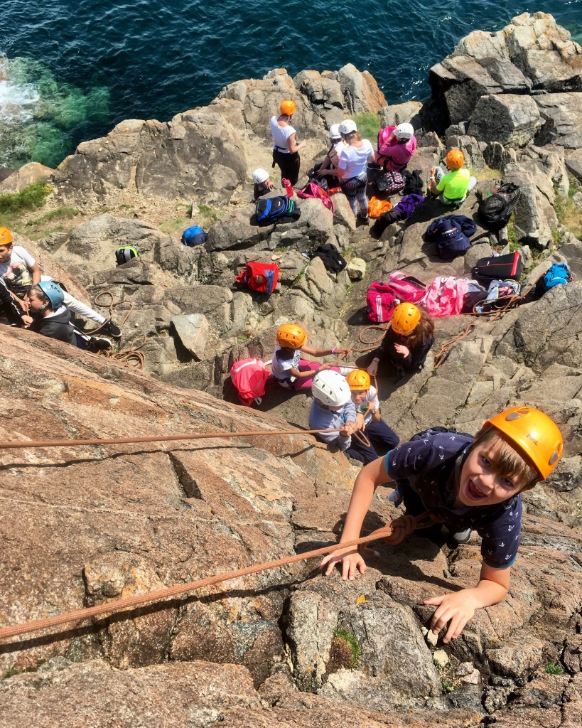 A school group climbing in Pembrokeshire
